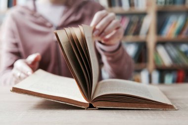 Siyah arka plan üzerine bir yığın kitap, düzgünce düzenlenmiş kitaplar. Kütüphanelerdeki rafların çoğunda kitabın omurgasında (numaralar, kodlar veya etiketler) net işaretler bulunan boy, konu veya türe göre düzenlenmiş kitaplar vardır. Kütüphaneler sessiz yerlerdir.