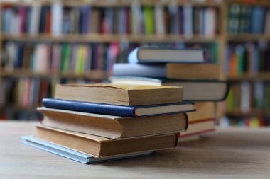 Siyah arka plan üzerine bir yığın kitap, düzgünce düzenlenmiş kitaplar. Kütüphanelerdeki rafların çoğunda kitabın omurgasında (numaralar, kodlar veya etiketler) net işaretler bulunan boy, konu veya türe göre düzenlenmiş kitaplar vardır. Kütüphaneler sessiz yerlerdir.