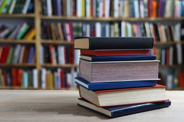 Siyah arka plan üzerine bir yığın kitap, düzgünce düzenlenmiş kitaplar. Kütüphanelerdeki rafların çoğunda kitabın omurgasında (numaralar, kodlar veya etiketler) net işaretler bulunan boy, konu veya türe göre düzenlenmiş kitaplar vardır. Kütüphaneler sessiz yerlerdir.