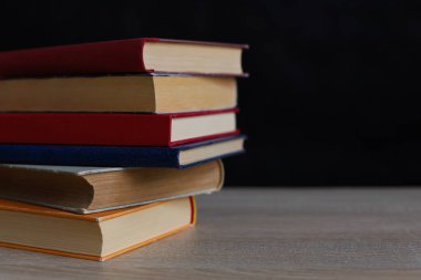 Siyah arka plan üzerine bir yığın kitap, düzgünce düzenlenmiş kitaplar. Kütüphanelerdeki rafların çoğunda kitabın omurgasında (numaralar, kodlar veya etiketler) net işaretler bulunan boy, konu veya türe göre düzenlenmiş kitaplar vardır. Kütüphaneler sessiz yerlerdir.