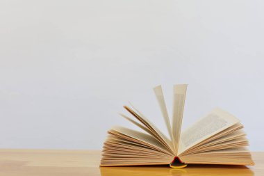 Kitap yığını ve beyaz arkaplan üzerine açık kitap