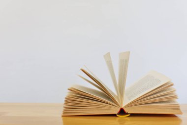 Tahta bir masanın üzerinde açık bir kitap.