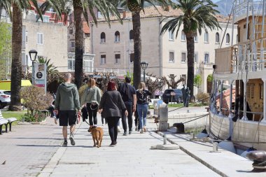 Makarska, Hırvatistan, 13.04.2025. Makarska rıhtımında turistler güneşli bir günde, liman ve yat limanında yürüyorlar.