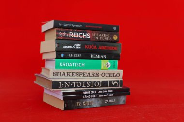 Vrgorac, Hırvatistan, 17.04.2025. Kütüphanede kitapları olan genç bir kütüphaneci, kütüphanedeki ahşap masada kitaplar.