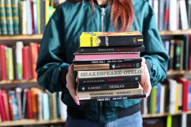 Vrgorac, Hırvatistan, 17.04.2025. Kütüphanede, edebiyatta, romanlarda, kısa öykülerde, şiirde, başyazıda, genç bir kadının elinde kitap tutarken, yüksek kaliteli kitaplar, eğitim, okul fotoğrafları,,