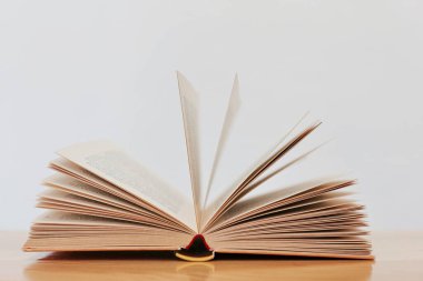 beyaz arkaplan üzerine açık kitap ve kitap yığını