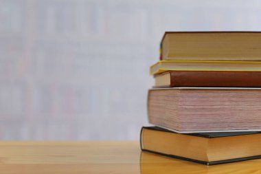 Tahta masadaki kitap yığını.