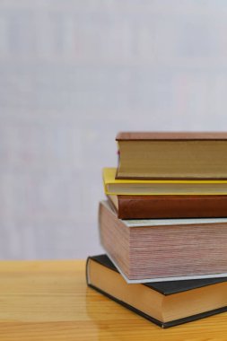 Kütüphanedeki beyaz ahşap masada yığınla kitap.