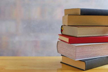 Tahta masadaki kitap yığını.