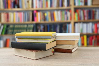 Kütüphanede ahşap arkaplan üzerine kitap yığını