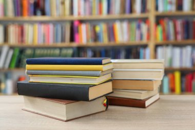 Kütüphanedeki masanın üzerinde kitap yığını