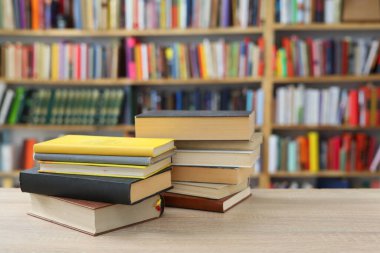 Kütüphanedeki masadaki kitap yığını. Metin için alan