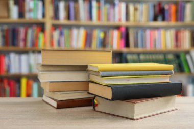 Tahta masadaki kitap yığını.