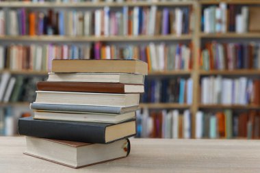 Kütüphanedeki masanın üzerinde kitap yığını