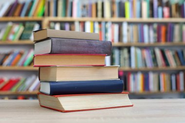 Tahta masadaki kitap yığını.