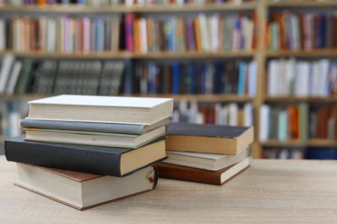 Kütüphanedeki masanın üzerinde kitap yığını
