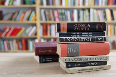 Kütüphanedeki masanın üstünde bir yığın kitap var.