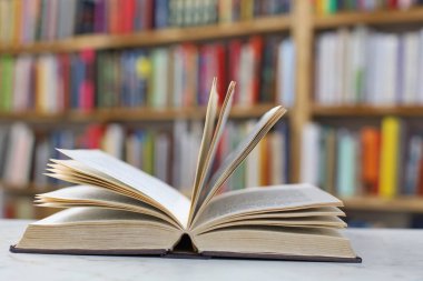Beyaz tahta masa, açık kitap, yüksek kaliteli kitaplar, eğitim, okul, kütüphane, raftaki kitaplar.