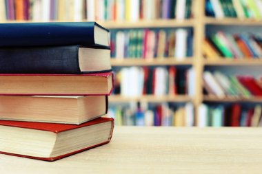 Açık bir kitap, ahşap masanın üzerinde yığınla kitap. Kopyalama alanı olan eğitim geçmişi. Okula geri dön.