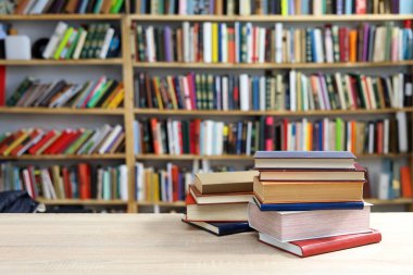 Kütüphanedeki masanın üzerinde kitap yığını