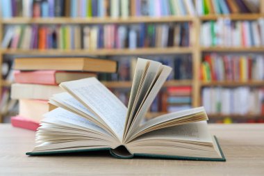 Kütüphanedeki masanın üstünde bir yığın kitap var.