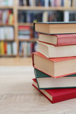 Kütüphanedeki masanın üzerinde kitap yığını