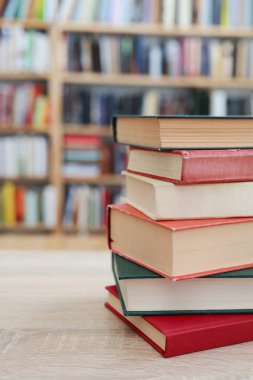 Kütüphanede ahşap masa üzerinde kitap yığını, metin için boşluk