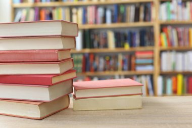 Kütüphanedeki masanın üzerinde kitap yığını