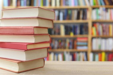 Bulanık arka plana karşı bir yığın kitap. Okula geri dön.