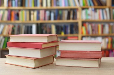 Kütüphanedeki masada yığınla kitap var.