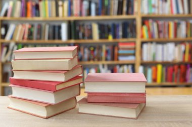 Kütüphanede ahşap arkaplan üzerine kitap yığını