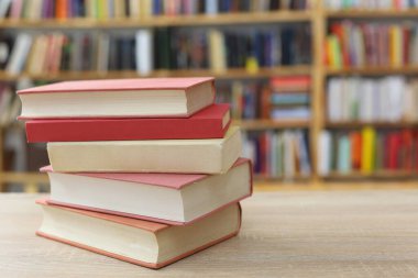 Kütüphanenin önündeki ahşap masada yığınla kitap. Metin için boşluk