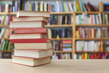 Bulanık arkaplana karşı masadaki kitap yığını