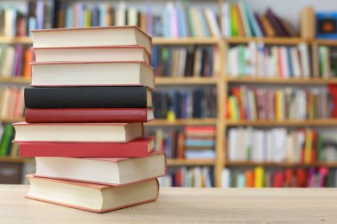 Kütüphanedeki masanın üzerinde kitap yığını