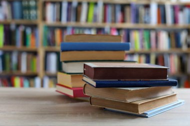 Kütüphanede ahşap arkaplan üzerine kitap yığını