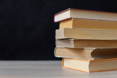 Tahta masadaki kitap yığını.