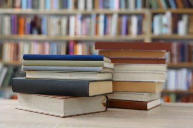 Kütüphanedeki masanın üstünde bir yığın kitap var.