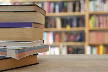 Kütüphanedeki masanın üzerinde kitap yığını