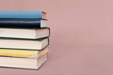 Pembe arkaplan üzerine kitap yığını
