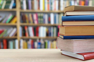 Tahta masadaki kitap yığını.