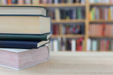 Tahta masanın üzerinde bir yığın kitap var.