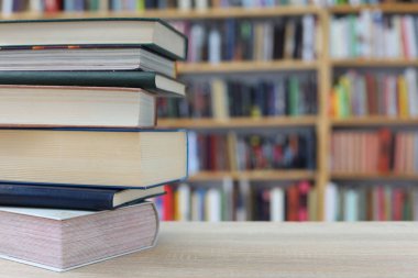 Tahta masadaki kitap yığını.