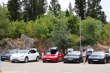 Vrgorac, Hırvatistan, 26.07.2025. Tesla arabaları güney Hırvatistan 'daki bir elektrikli otomobil şarj istasyonunda şarj olmayı bekliyor
