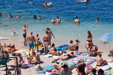 Makarska, Hırvatistan, 30.07.2025. Hırvatistan 'da yıllık tatil yapan turistler deniz ve güneşin keyfini çıkarıyorlar
