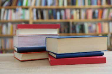 Bulanık arka plana karşı ahşap masadaki kitap yığını