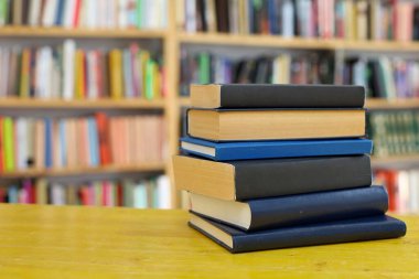 Kütüphanedeki masanın üzerinde kitap yığını