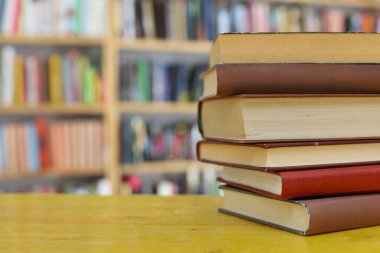 Kütüphanedeki ahşap masada yığınla kitap. okul konseptine geri dön.
