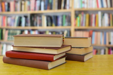 Tahta masadaki kitap yığını.