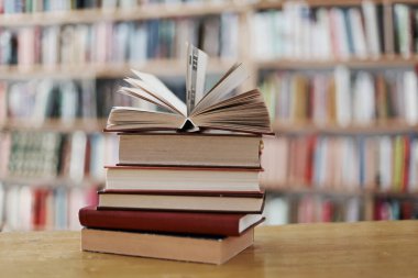 Kütüphanedeki masanın üzerinde kitap yığını, metin için boşluk