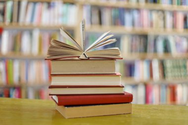 Tahta masadaki kitap yığını.